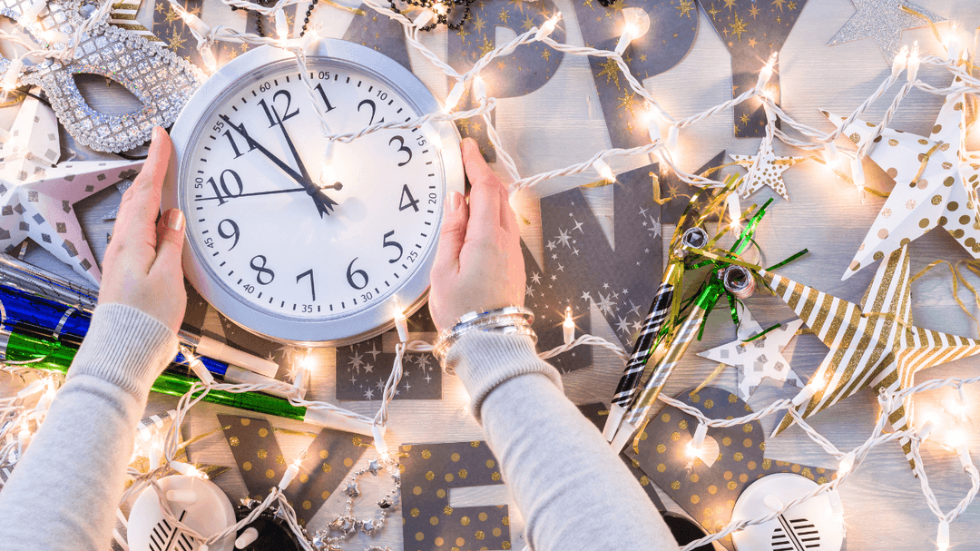 clock-beside-christmas-lights-and-wrapping-paper.png