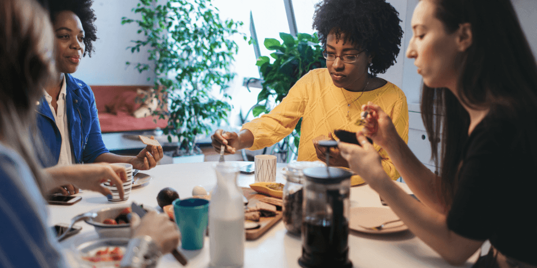 four-women-eating-around-table.png