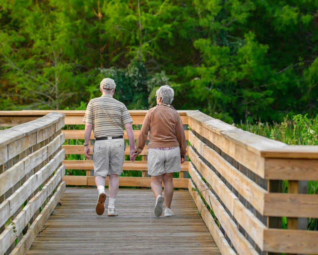 senior-couple-walking-across-beach.jpg