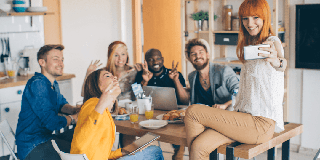 six-young-adult-friends-taking-selfie-around-table.png