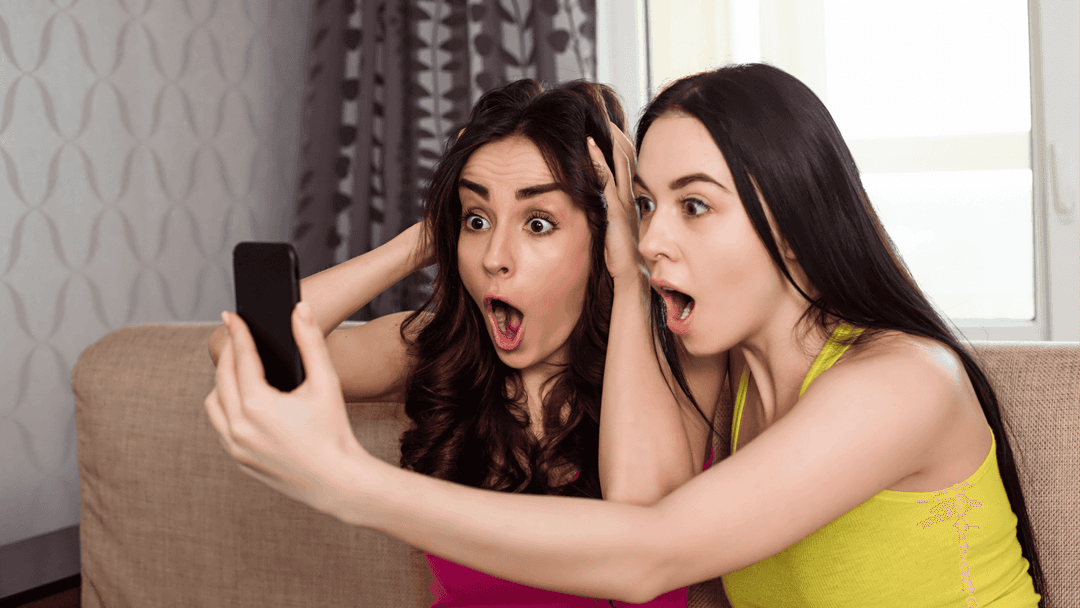two-girls-looking-surprised-at-phone.png